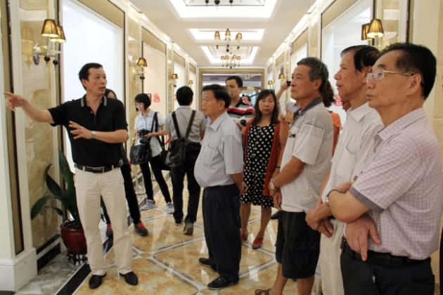 圖3、宏陶市場總監(jiān)霍達炎（左一）在為參觀者介紹釉面磚展示空間.jpg